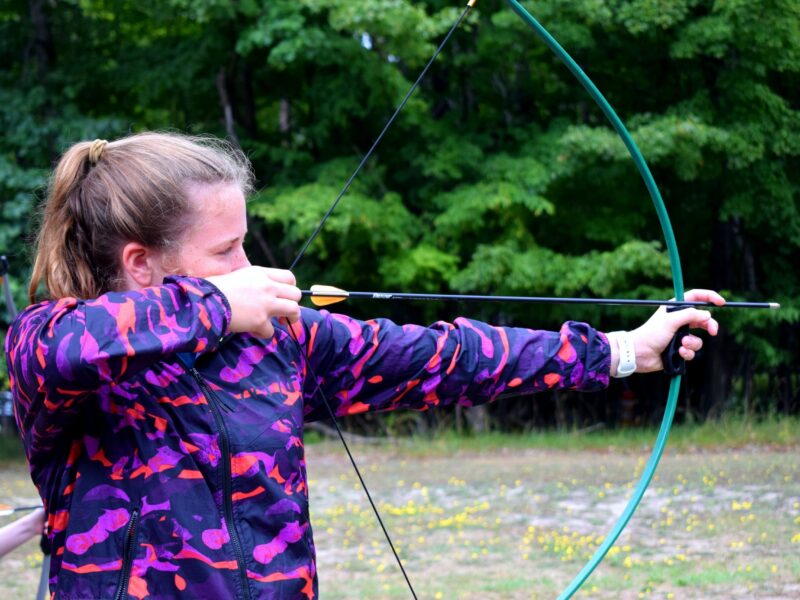 close-up photography of girl holding composite bow